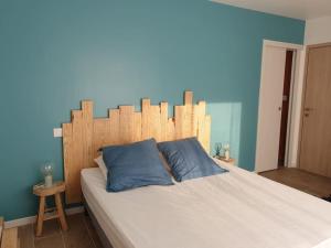 1 dormitorio con 1 cama grande y cabecero de madera en Maison neuve proche du lac de Léon et de l'Océan, en Vielle-Saint-Girons