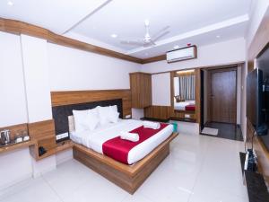 1 dormitorio con 1 cama grande y TV en Hotel Chiranjeevi Kolhapur en Kolhapur