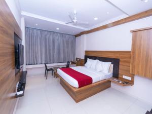 Habitación de hotel con cama y TV en Hotel Chiranjeevi Kolhapur en Kolhapur