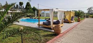 a pool with two beds and a gazebo next to aophethritis at Ktima Xiliadou in Chiliadou