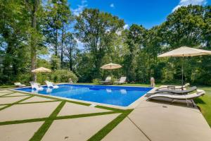 a swimming pool with chairs and umbrellas at Spacious Durham Home with Fire Pit and Hot Tub! in Durham