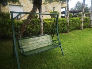 una panchina dondolante nell'erba in un cortile di Villa Girasole a Monteroni di Lecce