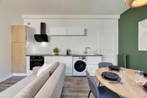 eine Küche und ein Esszimmer mit einem Sofa und einem Tisch in der Unterkunft Le Général Appartement proche des quais ! in Rouen