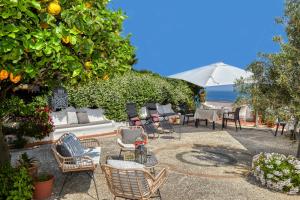 un patio con sillas, mesas y un árbol en Acquaviva 31, en Capri