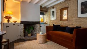 a living room with a couch and a fireplace at Armada Cottage in Charlbury