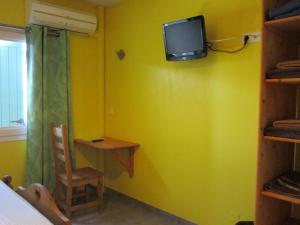 Saint-Jean-de-Maruéjols-et-AvéjanにあるLou Quinsouの黄色の壁の客室(壁にテレビ付)