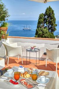 uma mesa com comida e vista para o oceano em Acquaviva 31 em Capri