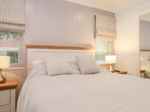 sypialnia z białym łóżkiem z 2 poduszkami w obiekcie Serendipity w mieście Windermere