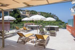 een patio met stoelen, tafels en parasols op een dak bij FUTURA SMART Flat Sorrento in Sorrento