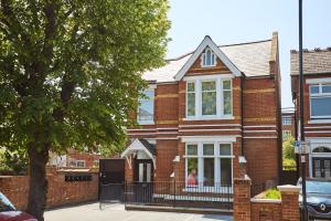 a brick house with a tree in front of it at Ealing Broadway by Viridian Apartments in Ealing