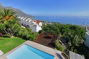 a villa with a swimming pool and a view of the ocean at Camps Bay Villa Views Pool Garden in Cape Town