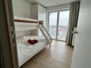 米德爾克爾克的住宿－Gezinsappartement in Middelkerke - Noort-C，一间卧室设有一张双层床和大窗户。
