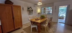 una sala da pranzo con tavolo e sedie in legno di וילה גלילית עם ג'קוזי מפנק a Qiryat ‘Amal