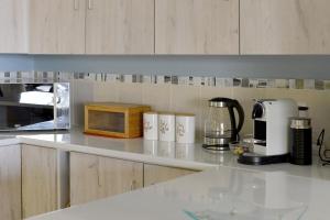 a kitchen with a counter top with a microwave at Camps Bay Villa Views Pool Garden in Cape Town