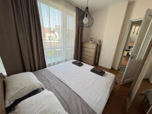 a bedroom with two beds and a large window at Apartment Happy Holiday 2 in Burgas City