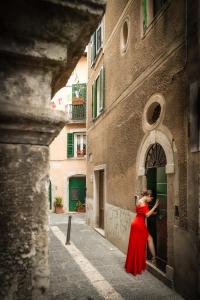 una mujer con un vestido rojo parada fuera de un edificio en Wonderfalls Cascate del Liri, en Isola del Liri
