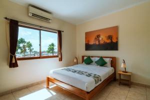 a bedroom with a bed and a large window at Umah Kita in Seminyak