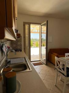 uma cozinha com um lavatório e uma sala de estar em Villa in campagna vicina al mare ( nuova anno 2022) em Uggiano la Chiesa