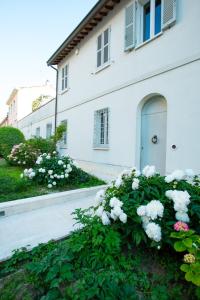 una casa bianca con fiori bianchi davanti di Au petit jardin a Ravenna