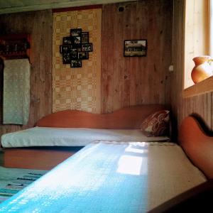 um quarto com uma cama num quarto de madeira em Lakefront Log House and Sauna em Ginučiai