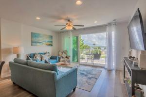 a living room with a couch and a tv at New Luxury Condo w/ Heated Pool 1 Block From Gulf in St Pete Beach
