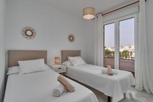 Dos camas en una habitación con ventana. en Nerja Atico, en Nerja 37 fotos más