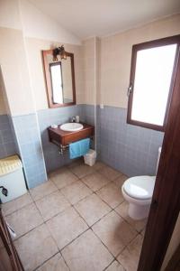 a bathroom with a toilet and a sink and a mirror at Piedras Vivas in Anora
