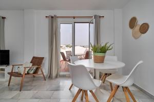 Un comedor blanco con una mesa y sillas. en Nerja Atico, en Nerja