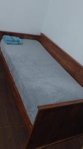 - un lit avec un cadre en bois et un matelas bleu dans l'établissement LS Alojamientos Posadas Misiones, à Posadas