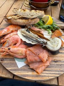 a plate of food with seafood on a wooden table at The Bubble Hideaway - A Little Oasis near the Sea in Whitstable