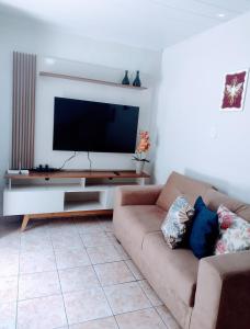 salon z kanapą i telewizorem z płaskim ekranem w obiekcie Casa aconchegante ao lado da Igreja Matriz- Bananeiras-PB w mieście Bananeiras