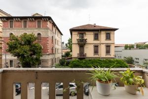 a balcony with three potted plants on a building at Espinasse Apartment in Milan
