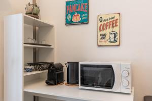 un forno a microonde seduto su un bancone in cucina di Espinasse Apartment a Milano