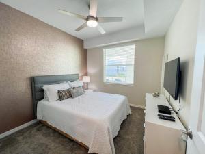 um quarto com uma cama e uma televisão de ecrã plano em Lake view Luxury Condo at Storey Lakes em Kissimmee