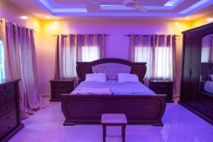 a bedroom with a bed with purple walls and curtains at Brusubi Creek in Brusubi