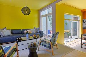 a living room with yellow walls and a blue couch at Bo-Kaap Elegance Historic Luxury & Mountain Views in Cape Town