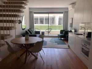 eine Küche und ein Wohnzimmer mit einem Tisch und Stühlen in der Unterkunft Oasis 28 by Innkeeper in Lissabon