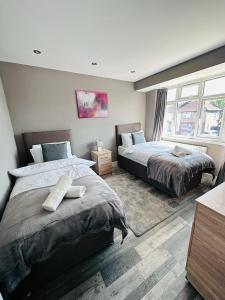 a bedroom with two beds and a window at Burmese - 5 Bedroom House in Earley