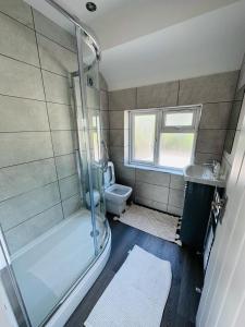 a bathroom with a shower and a toilet and a sink at Burmese - 5 Bedroom House in Earley
