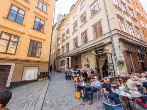 a group of people sitting at tables outside a building at ApartDirect Gamla Stan III in Stockholm
