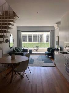 eine Küche und ein Wohnzimmer mit einem Tisch und Stühlen in der Unterkunft Oasis 28 by Innkeeper in Lissabon
