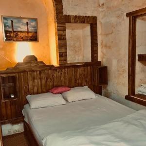 a bedroom with a bed with a wooden head board at Alkan mozayik otel in Urfa