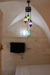 um quarto com uma televisão e um lustre em Alkan konuk evi em Şanlıurfa