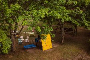 widok na park zabaw z drzewem w obiekcie Pokoje u Małgosi w mieście Kosewo