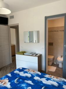 ein Schlafzimmer mit einem Bett und ein Badezimmer mit einem Waschbecken in der Unterkunft Casa Marisa in Camporosso