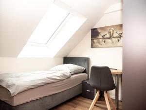 1 dormitorio con cama, escritorio y silla en Pension HSL en Graben-Neudorf