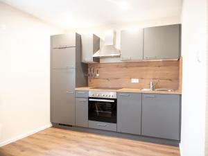 cocina con electrodomésticos de acero inoxidable y suelo de madera en Pension HSL en Graben-Neudorf