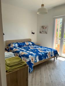 a bedroom with a bed with a blue comforter at Casa Marisa in Camporosso