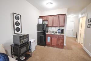 a kitchen with brown cabinets and a black refrigerator at Stay at the Historic Inman in Champaign