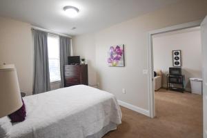 1 dormitorio con 1 cama, vestidor y ventana en Stay at the Historic Inman en Champaign